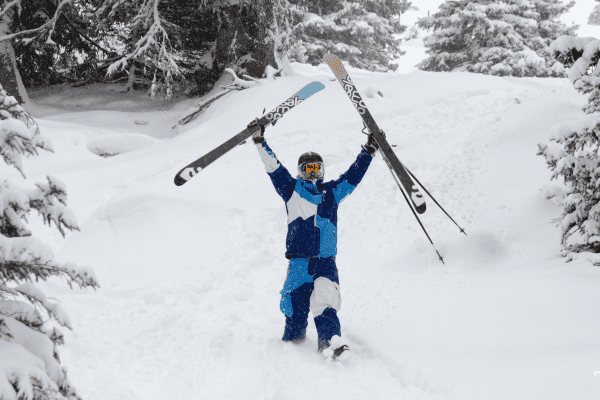 Skifahrer streckt Skier in die Luft