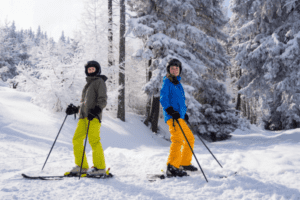 Zwei Jugendliche auf Skiern im Wald